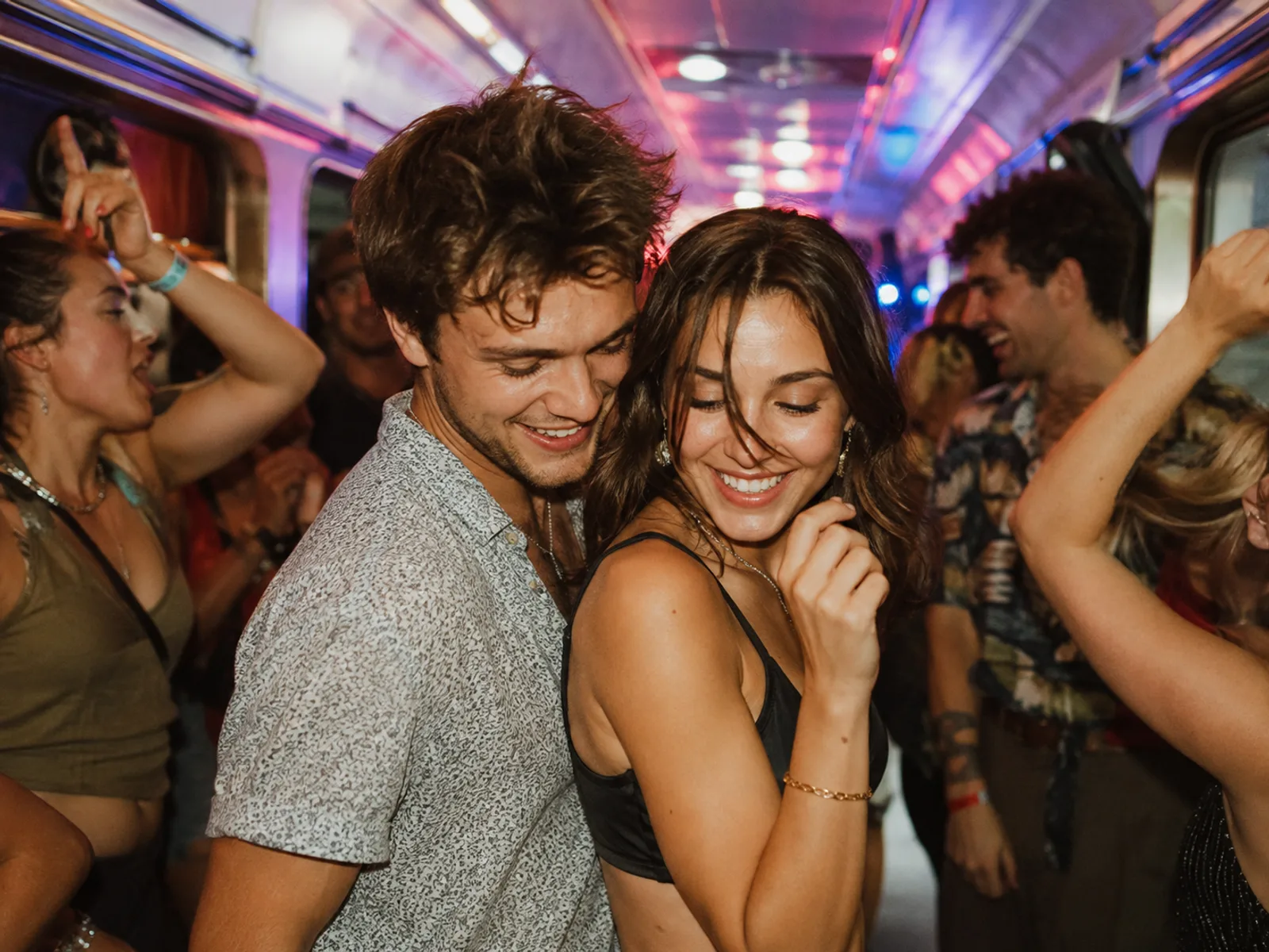 Lachende Freunde halten sich im fahrenden Partyzug fest
